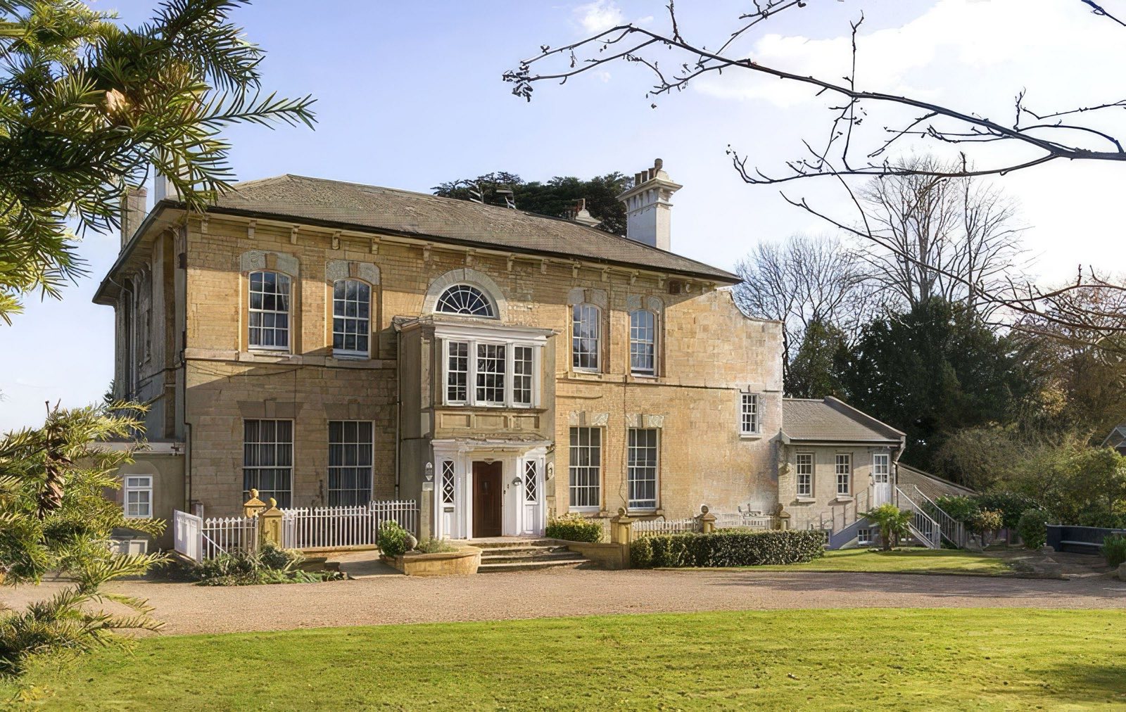 Wray Park, a listed Georgian mansion set behind lawns and mature trees in Reigate
